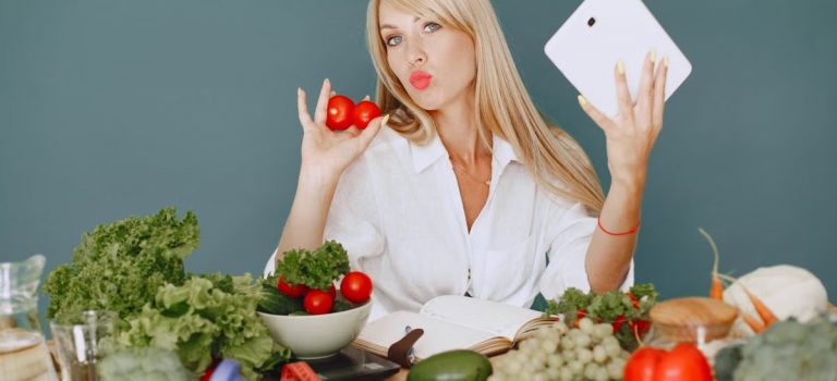 Vlogger promoting healthy eating with fresh vegetables on the table.
